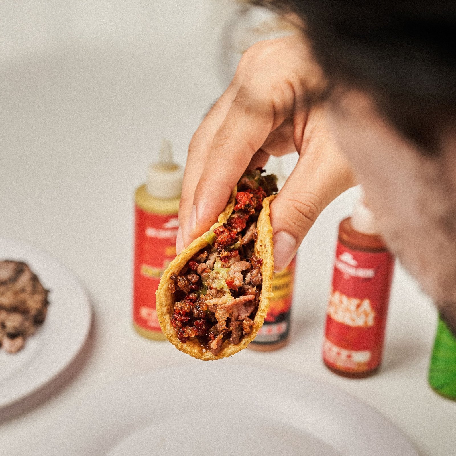 persona agarrando un taco campechano