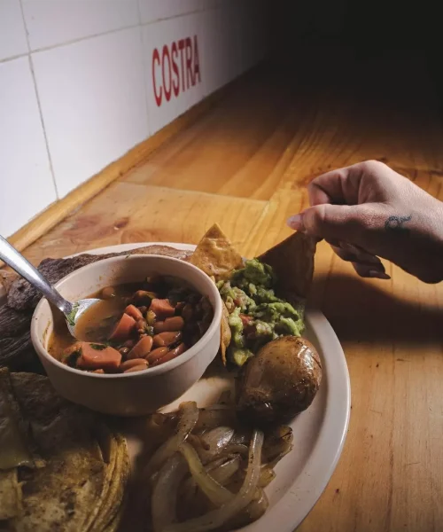 Frijoles charros y orden de guacamole en taquería