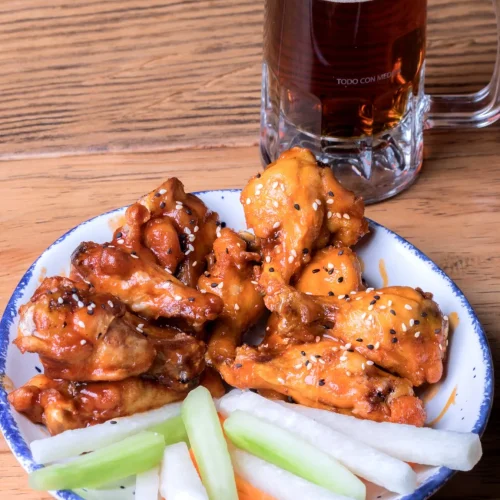 Deliciosas alitas marinadas con pepino y zanahoria en el restaurante bife sport bar