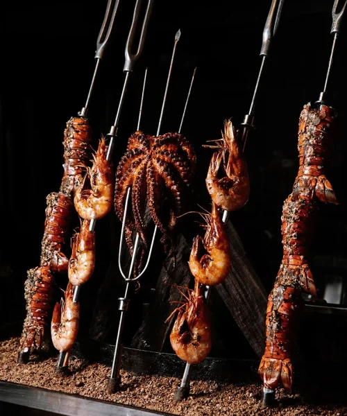 Platillos de mar, espadas con camarones, pulpos y lagostas a las brasas en el buffet bovinos steakhouse playa