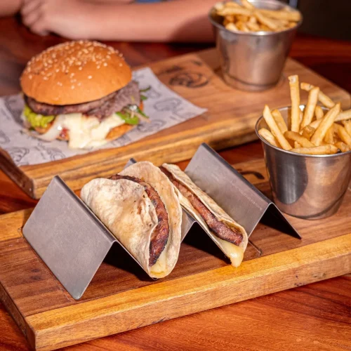 Hamburguesas de res y tacos de carne acompañados de papas fritas en leo