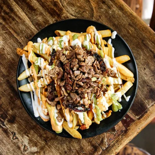 Papas fritas con carne asada en el restaurante el canibal