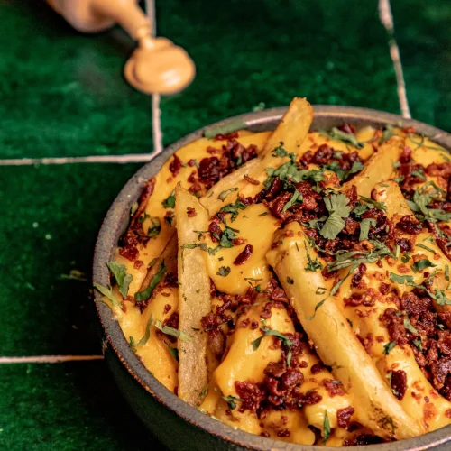 Papas fritas con tocino y queso derretido en mu burger house