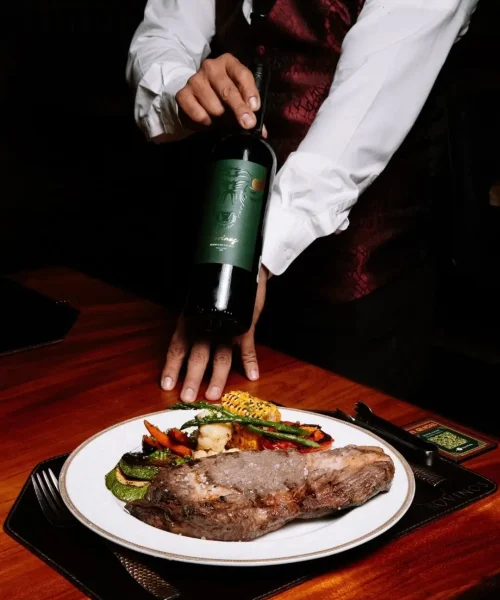 platillo de corte de carne con un vino de la casa en el restaurante bovinos steakhouse